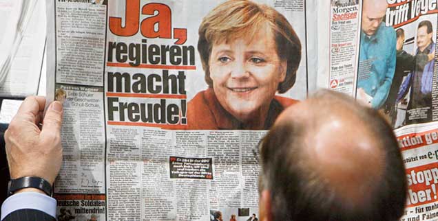Bild und Merkel sind seit Langem verbunden: Am 22. November 2006 liest ein Abgeordneter schon in der Zeitung, was die Kanzlerin im Bundestag sagen wird (Foto: pa/Kumm)