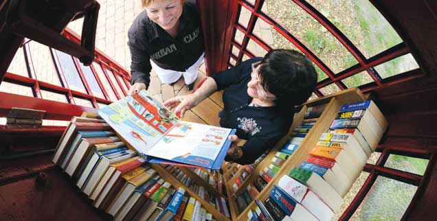 Die kleinste Bücherei der Stadt Bergen im Kreis Celle findet sich in einer ausgedienten britischenTelefonzelle. Hier stehen genau 334 Bücher. So sollte es auf jeden Fall sein, denn: Wer ein Buch leiht, lässt ein anderes zurück. Funktioniert ziemlich gut, finden Susanne Lau (links), Hauptamtsleiterin der Stadt, und Marion Apeah, Leiterin der Stadtbücherei. (Foto: pa/Hollemann)